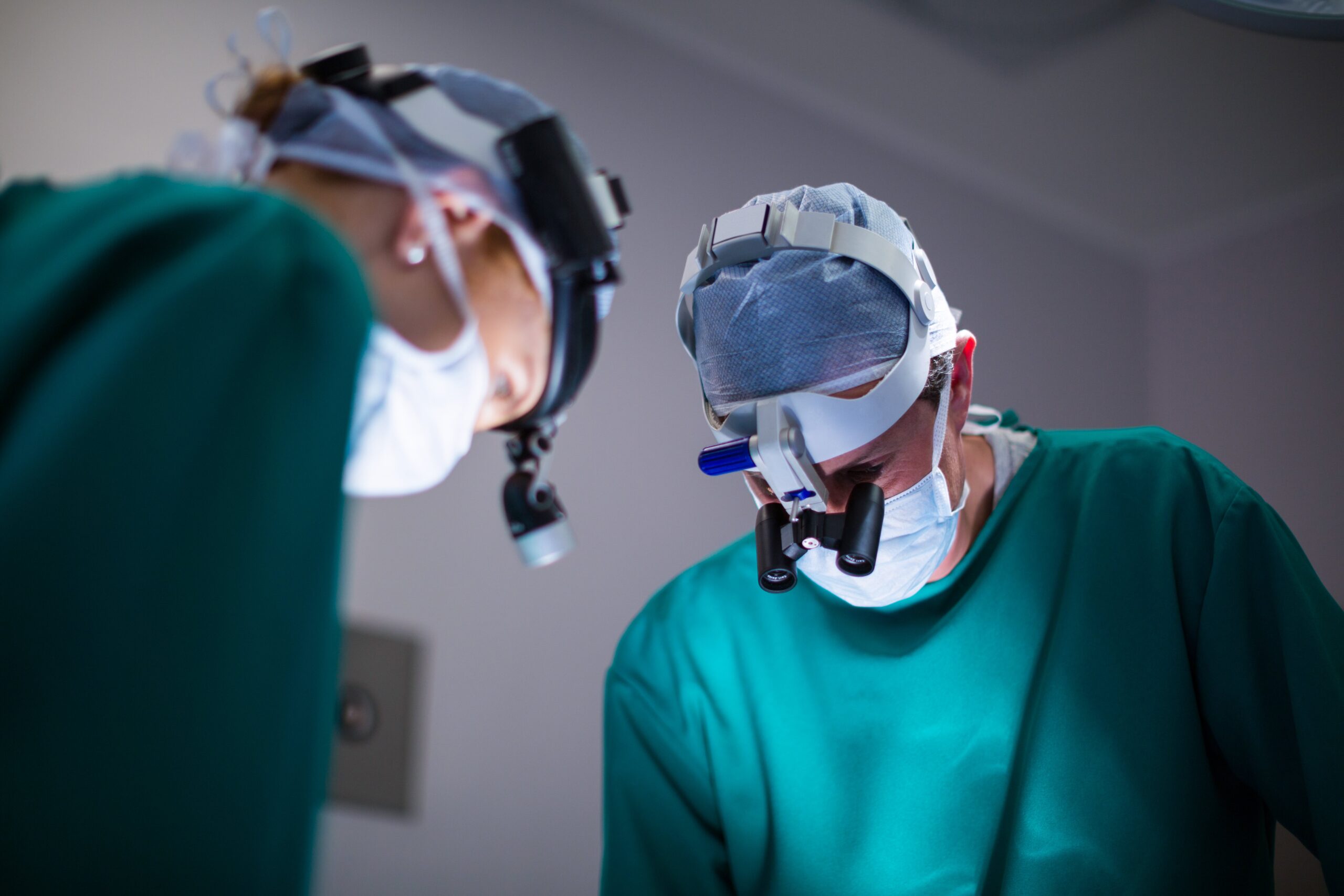 surgeons-wearing-surgical-loupes-while-performing-operation-min